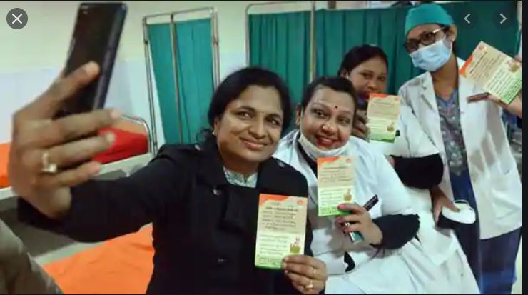 Frontline workers take a selfie with their vaccination record card after receiving the first dose of Covishield vaccine.